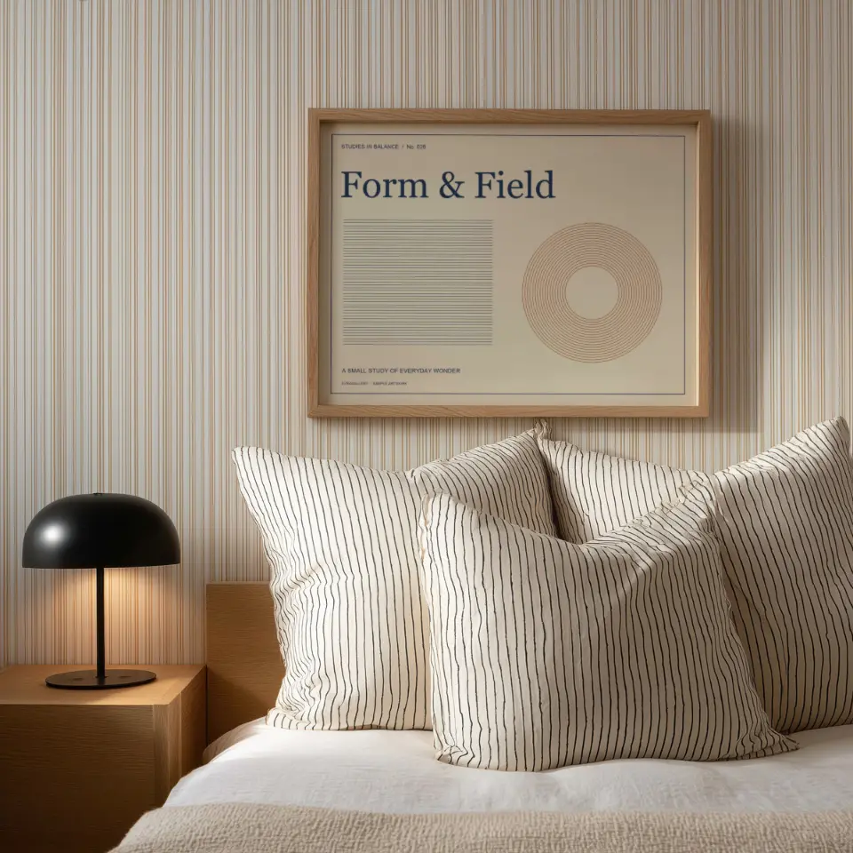 Striped bedroom: A slim natural-oak frame hangs on finely striped wallpaper above a bed piled with matching ticking-stripe pillows.