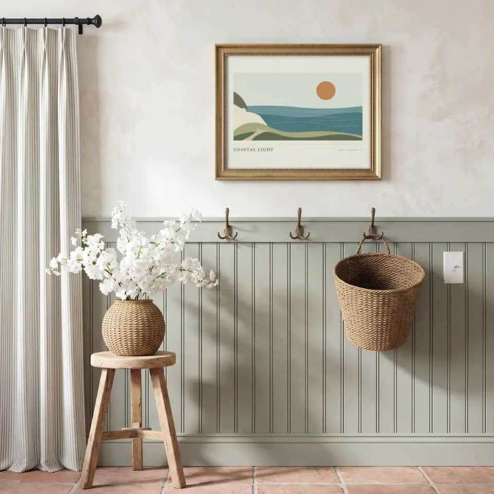 Blossoms by the Peg Rail: A gold frame hangs on a limewashed wall above sage-green beadboard fitted with brass hooks, from which a woven basket hangs.